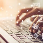 Hands typing on a laptop