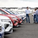 Men standing next to cars